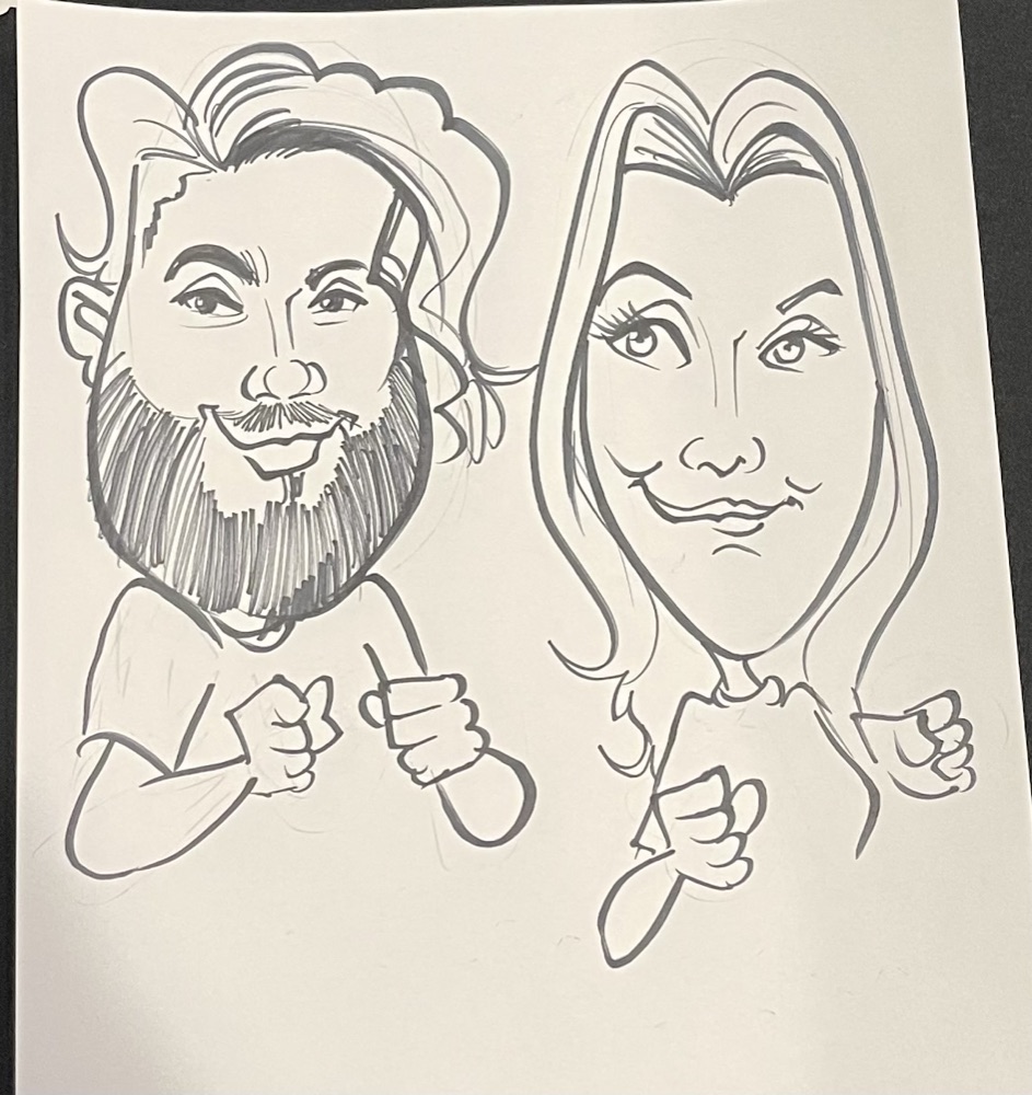 Black marker caricature of Matty, with a big beard and long swept-back hair, and Jacquie, with long straight hair, both holding up their fists